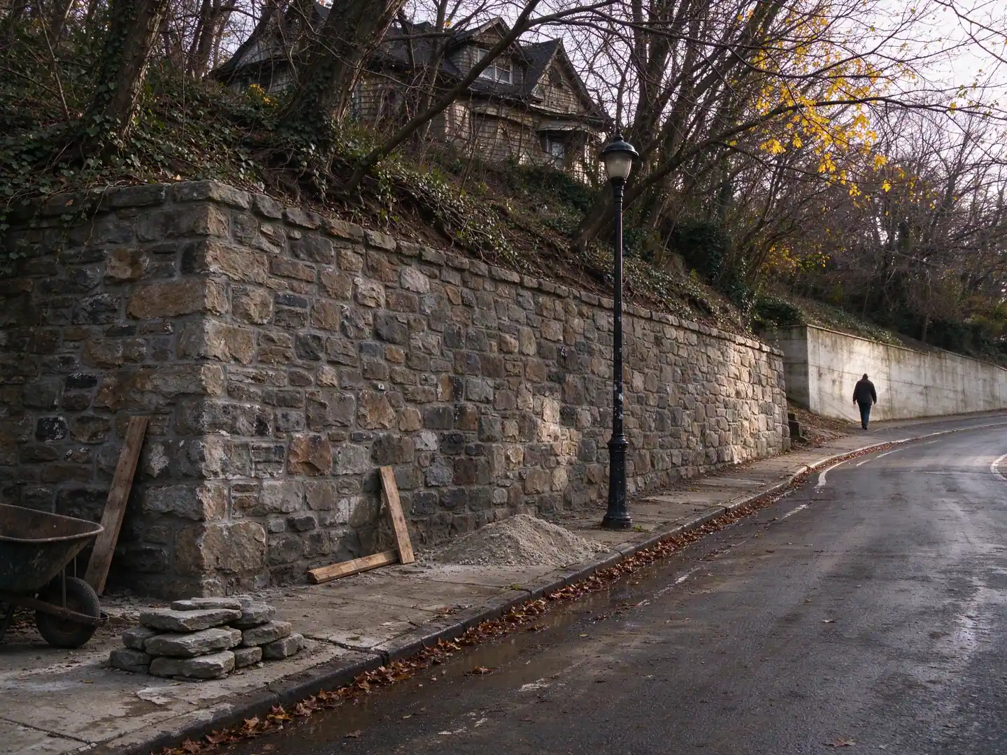 Tall mortared stone retaining wall along a steep hillside street on Grymes Hill, Staten Island, in late autumn